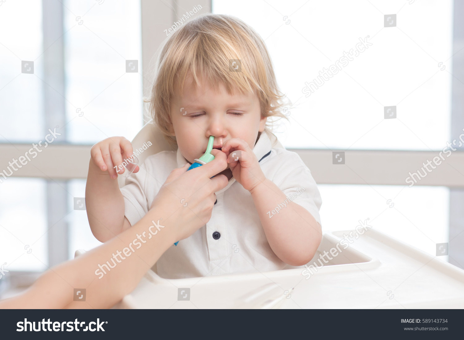 stock-photo-mother-using-baby-nasal-spray-for-the-common-cold-saline-sea-water-helps-heal-the-snot-for-child-589143734.jpg